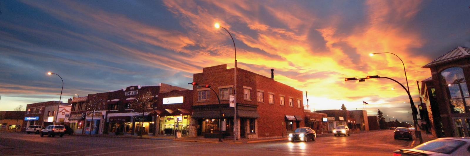 Downtown Olds, Alberta: brick storefronts along the main street under a bright orange sunset sky